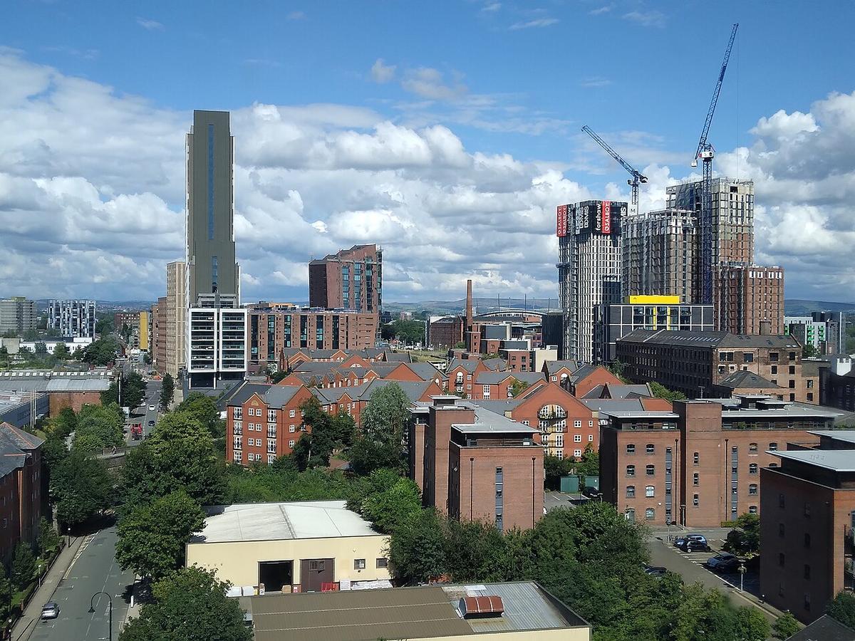 Rooftops of a residential neighbourhood in Manchester under a blue sky